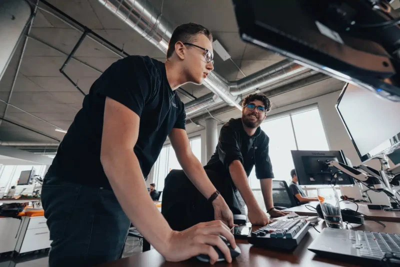 Two Kezber team members working at their screens